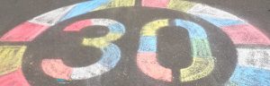 Ein buntes, mit Kreide auf die Straße gemaltes, Tempo 30 Schild